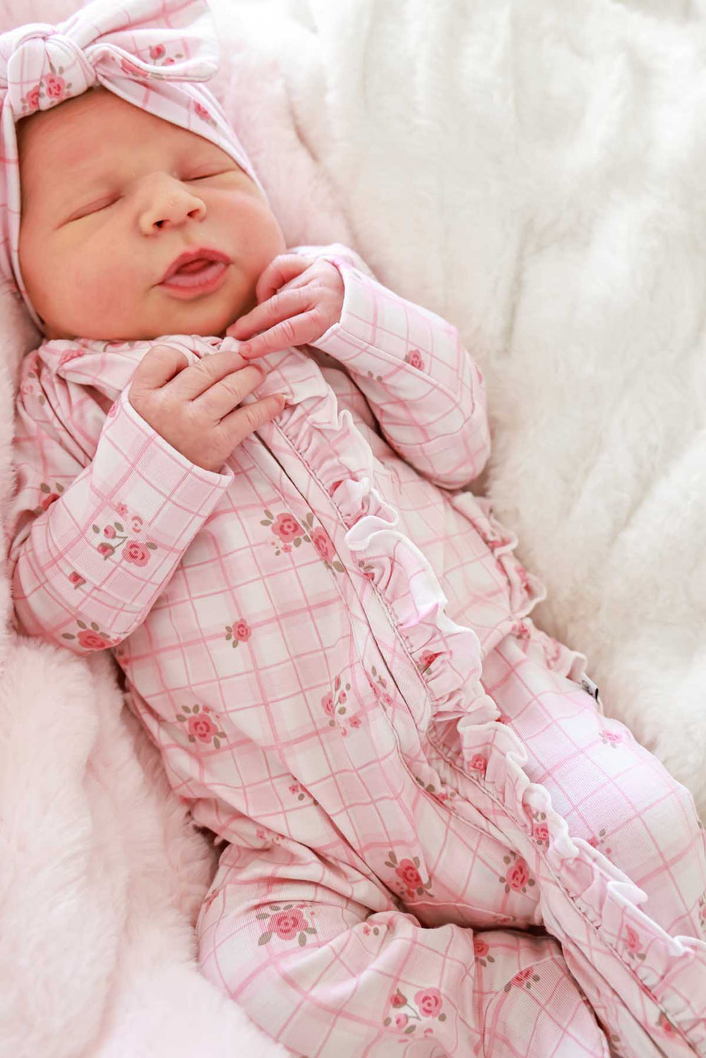 Sleeping newborn in Primrose Plaid footie and matching knotted cap