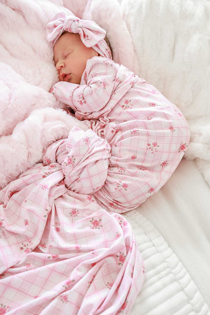 Newborn swaddled in oversized Primrose Plaid blanket with bow headwrap