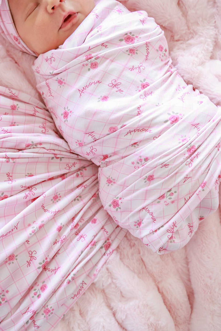 Close-up of baby face and personalized swaddle wrap detail