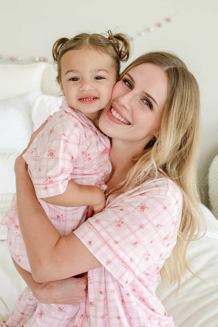 Close-up portrait of mother and daughter smiling cheek to cheek