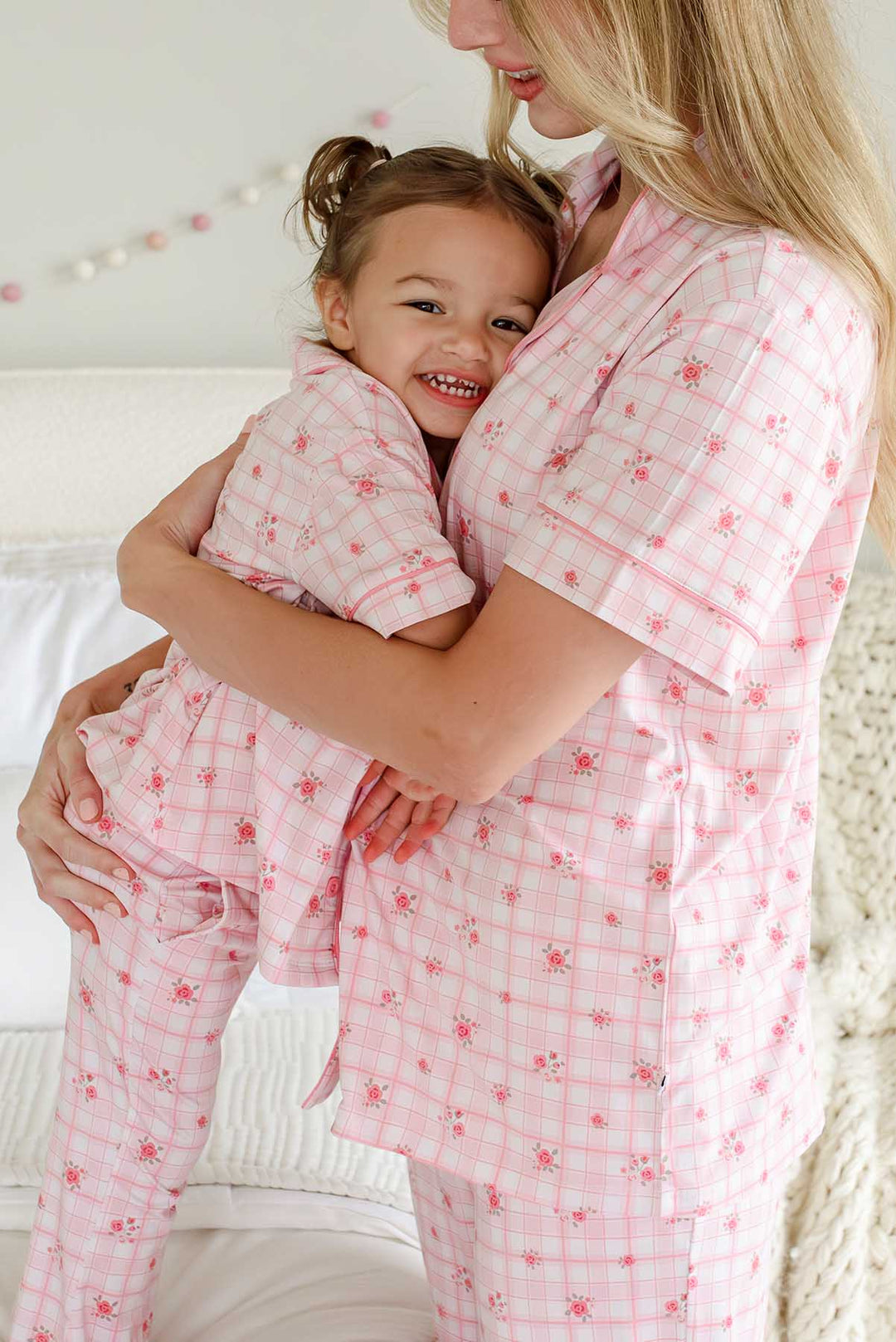 Mother and daughter sharing a joyful moment in plaid pajamas