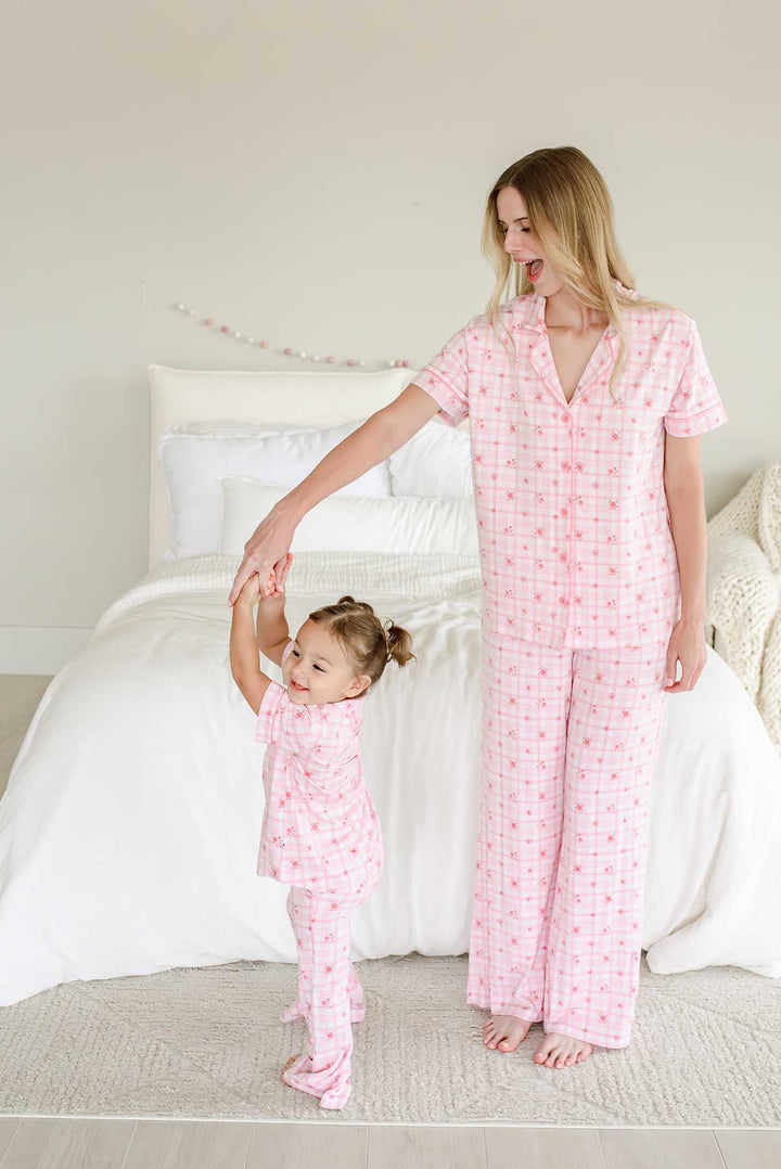 Mother and daughter dancing together in matching plaid loungewear