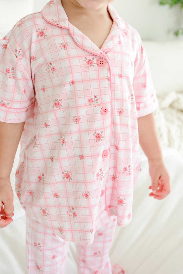 Close-up of collar and rose button detail on girls plaid top