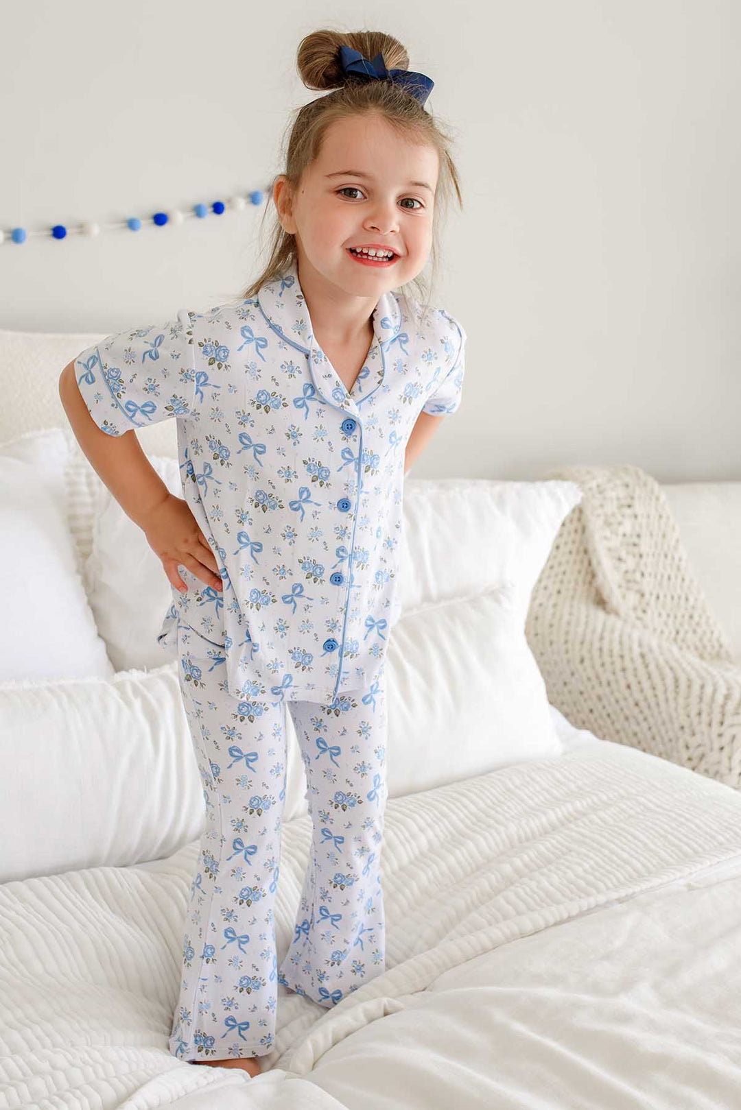 girl standing on bed with hands on hips in tied in blooms lounge sets