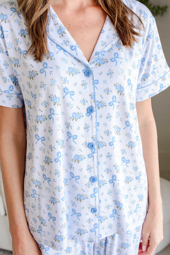 Close-up of the button-up top from a Tied In Blooms bamboo lounge set in blue floral and bow print