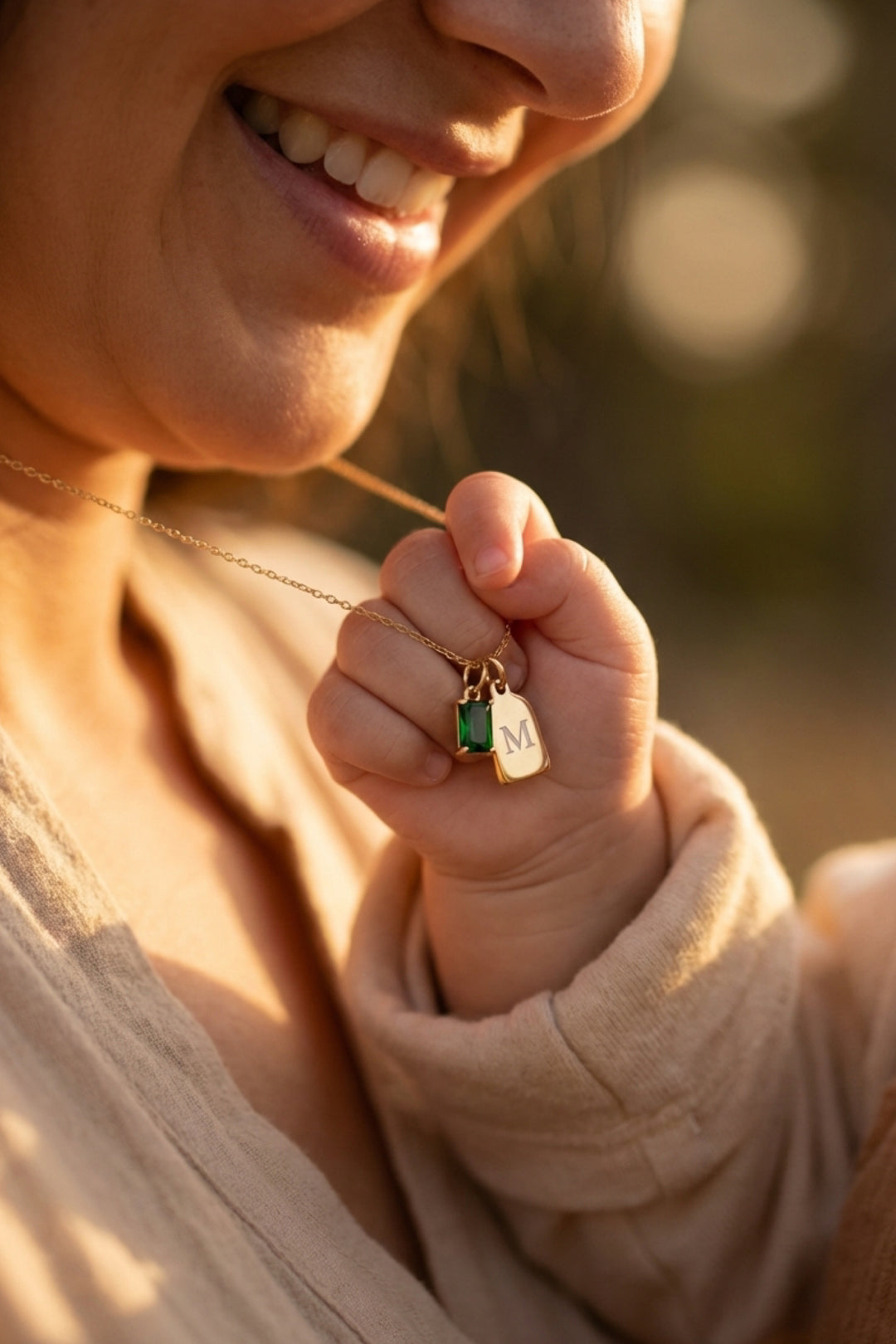 mom necklace with engraved tag charm and green birthstone in gold