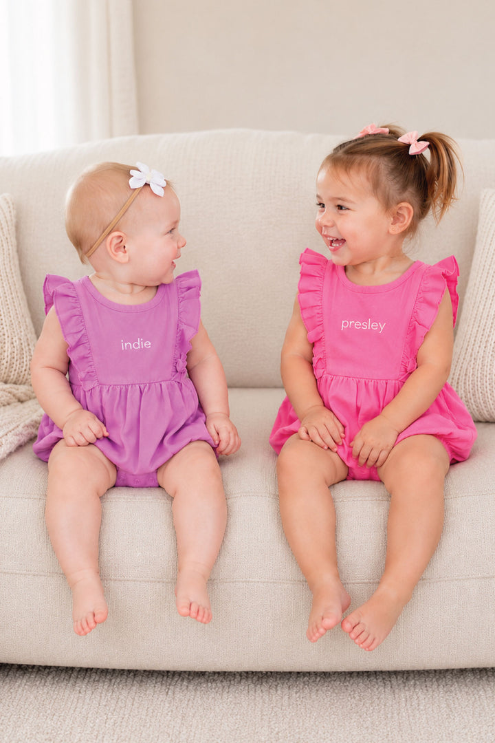 girls in pink and purple embroidered ruffle outfits