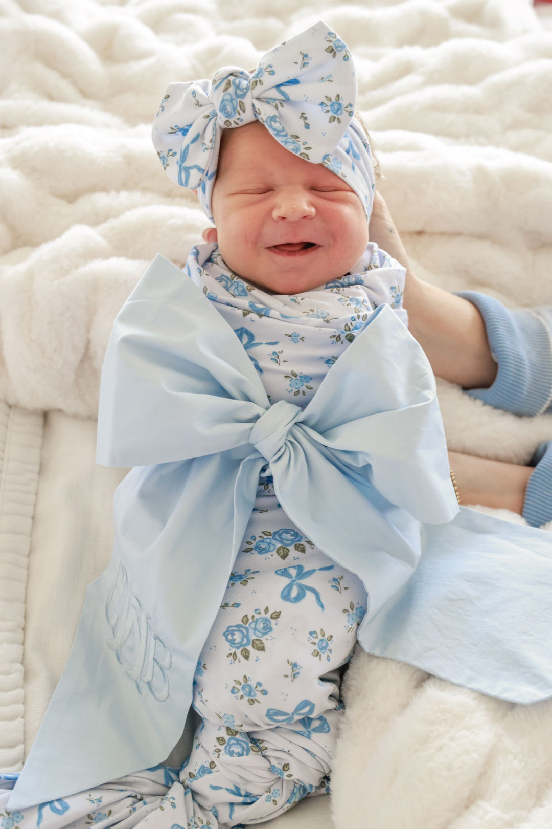 smiling girl in light blue newborn sash