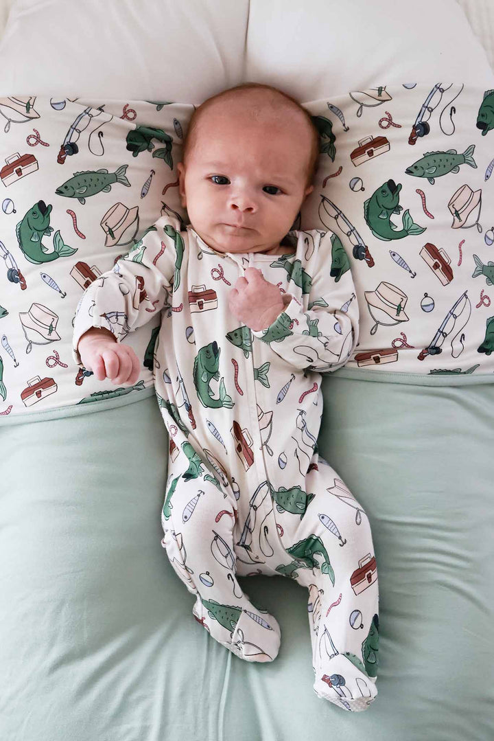 Newborn on fishing themed blanket wearing the Off The Hook zipper footie showing footed bottom detail
