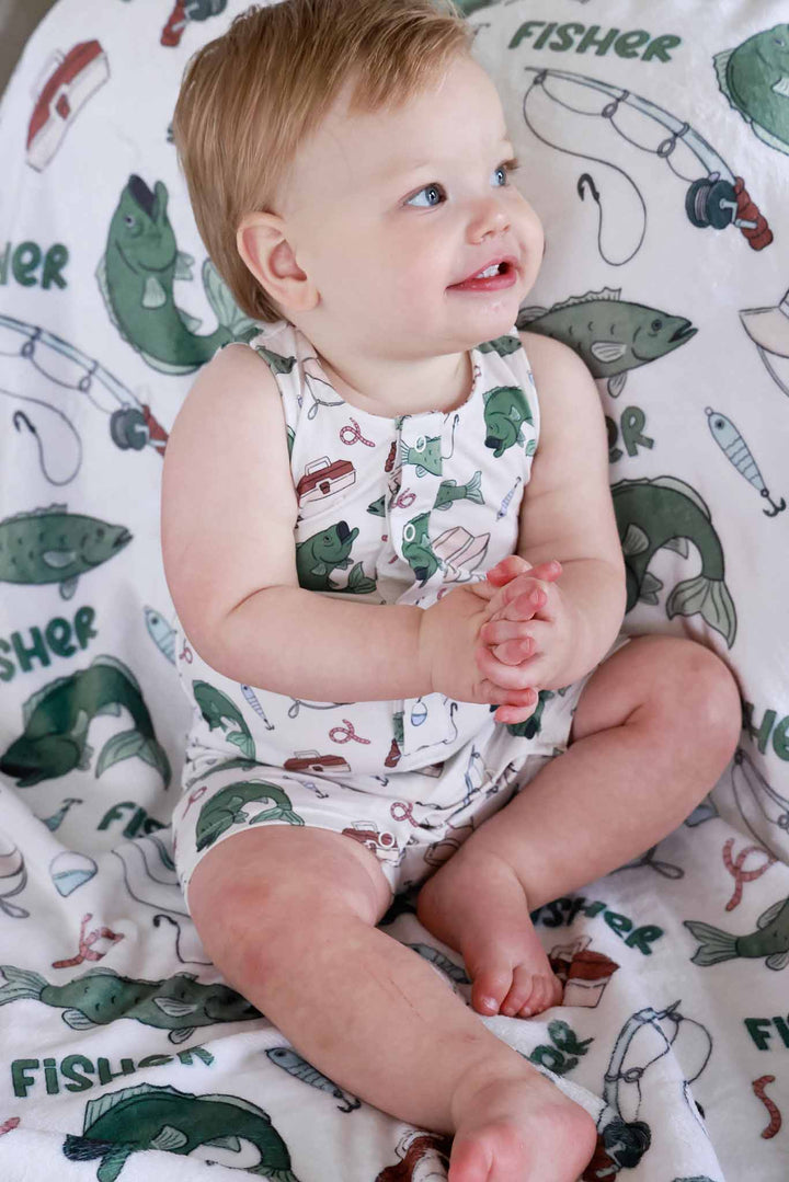 Baby sitting on the personalized Off The Hook fishing themed blanket wearing a sleeveless snap romper