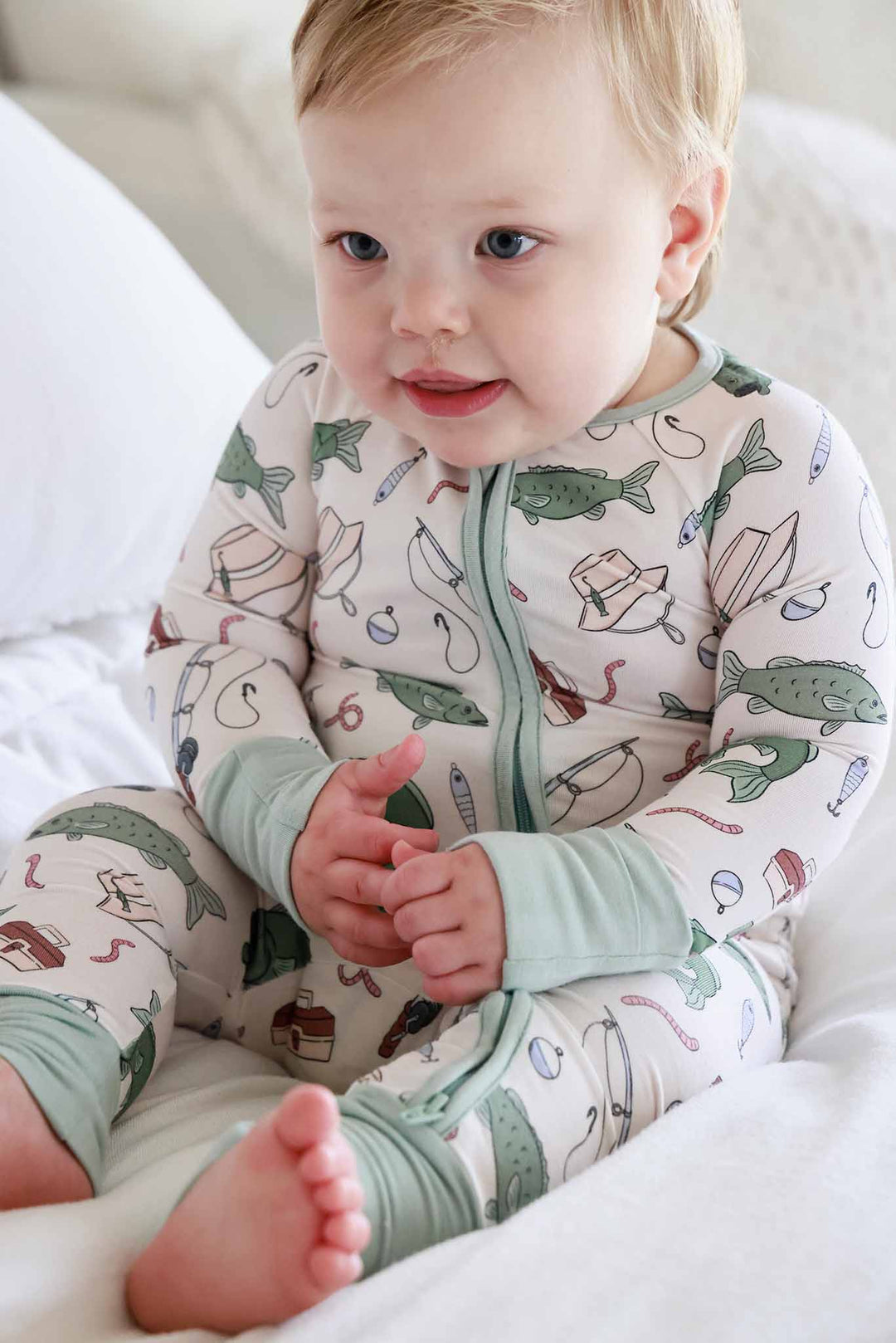 Baby sitting up wearing the Off The Hook convertible zip romper showing the front zipper and fishing print