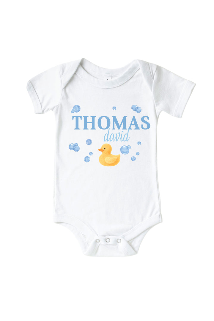 White baby bodysuit with personalized blue bubble duckie graphic design featuring yellow rubber duck, blue bubbles, and custom name on front