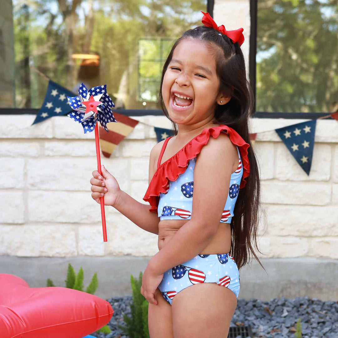 girl's one shoulder ruffle bikini with patriotic sunglasses 