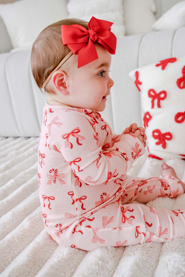 Side view of a baby wearing the Caden Lane Peppermint Bows Bamboo Waffle Convertible Zipper Romper, showcasing the festive bow print, breathable bamboo viscose waffle fabric, and cozy Christmas baby sleepwear.