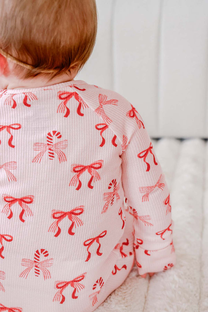 Back view of the Caden Lane Peppermint Bows Bamboo Waffle Convertible Zipper Romper, highlighting the all-over peppermint bow and candy cane print on ultra-soft bamboo viscose waffle knit for matching Christmas baby pajamas.