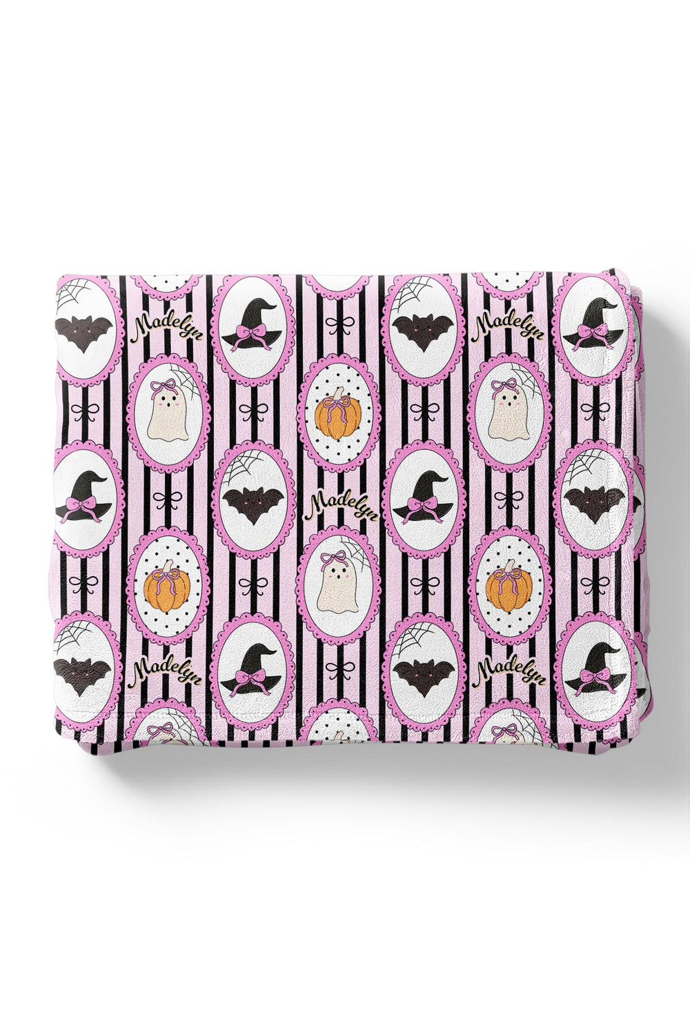 Folded fabric with Halloween-themed pattern featuring pumpkins, bats, and witches' hats on a white background.