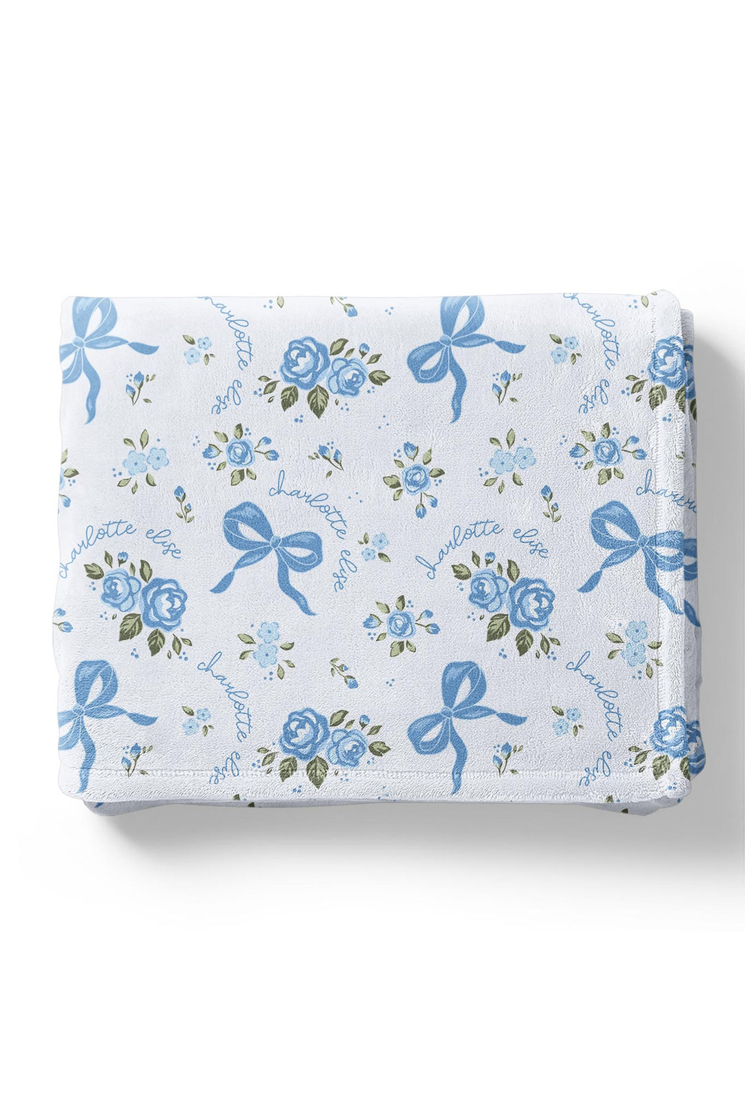 Folded Tied In Blooms blanket with blue floral and bow print, personalized with names embroidered in cursive script