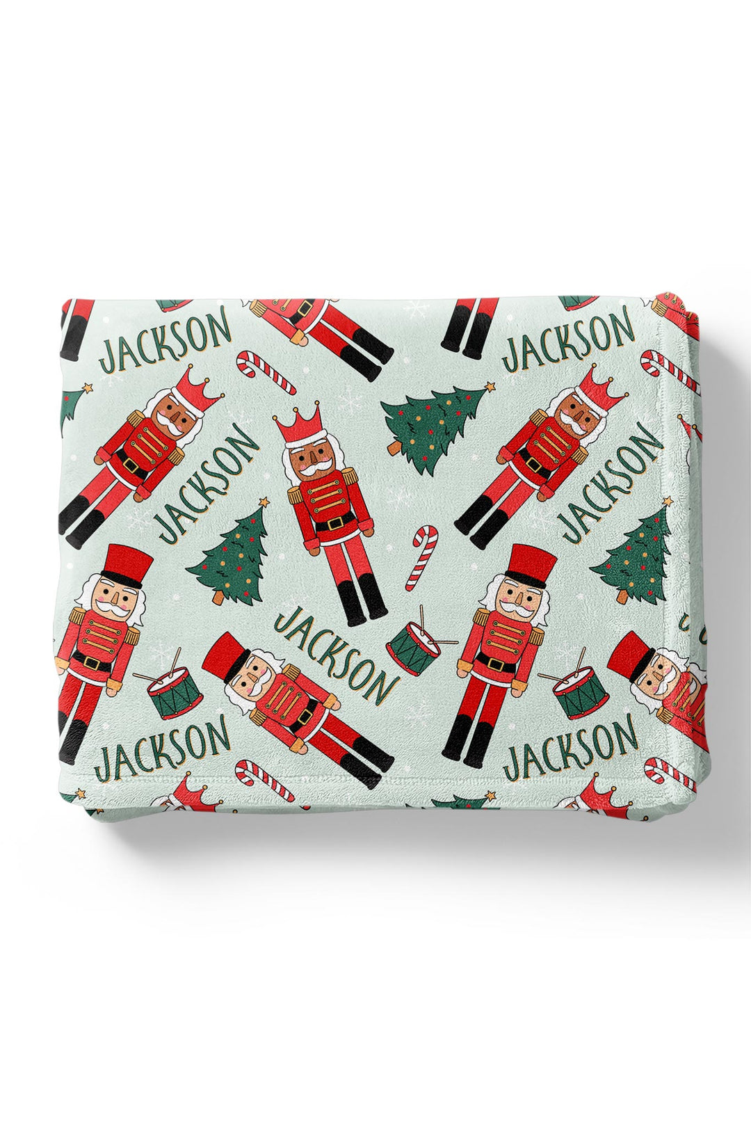 Personalized Caden Lane Toy Soldier Green kids Christmas blanket featuring red nutcrackers, Christmas trees, candy canes, drums, and a custom name.