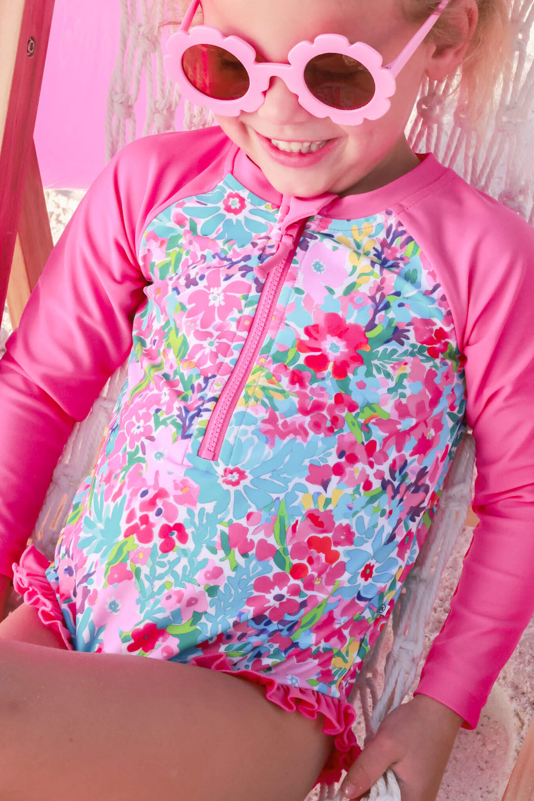 girl laying on beach chair in long sleeve petal splash swim rash guard 
