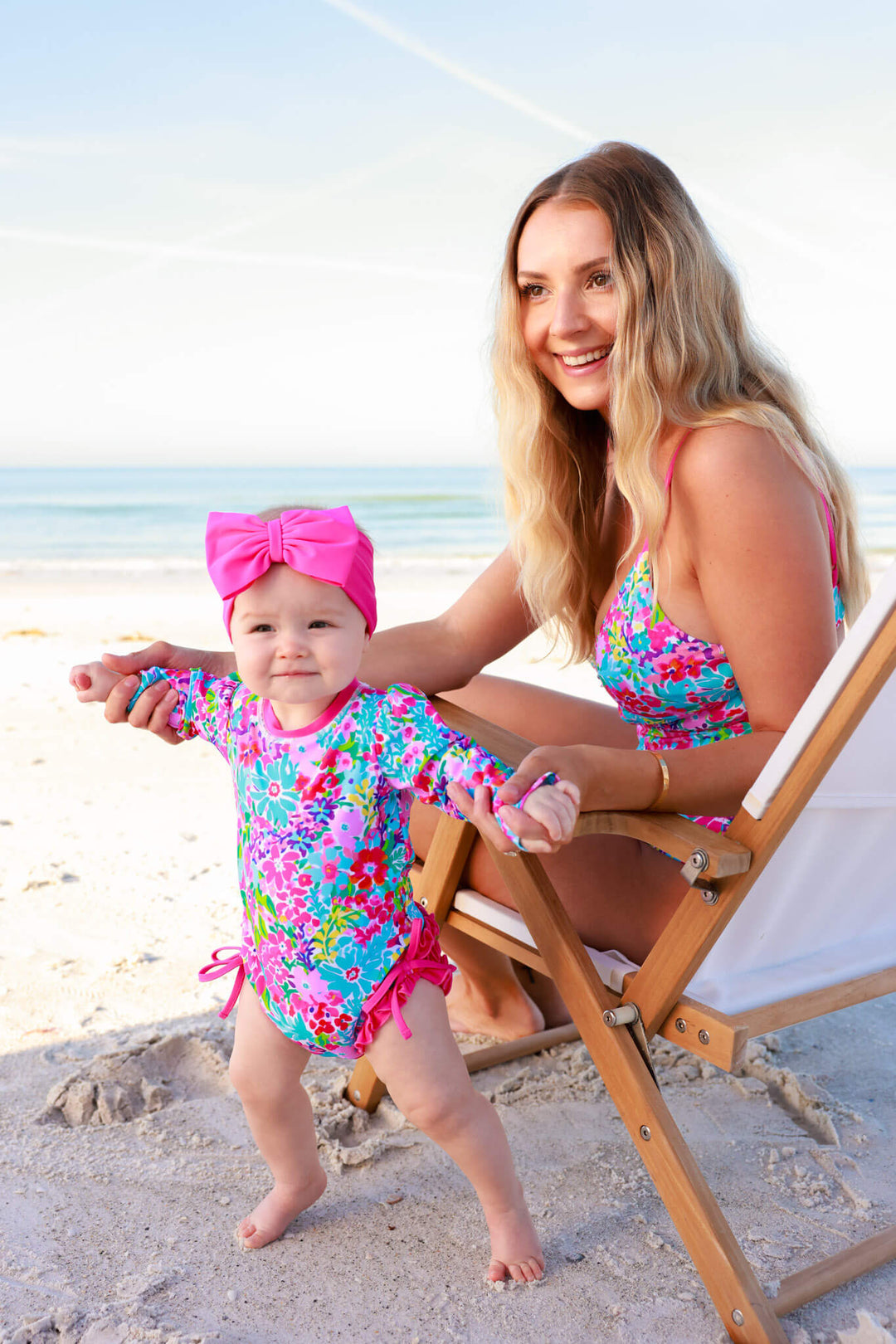 mom and daughter playing on the beach in petal splash matching swmsuits