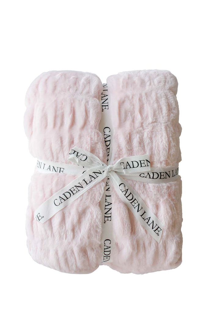 Folded double-ruched faux fur baby blanket in barely pink, tied with a Caden Lane ribbon