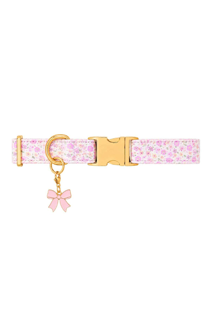 Pink floral pet collar with a pink enamel bow charm attached, shown on white background