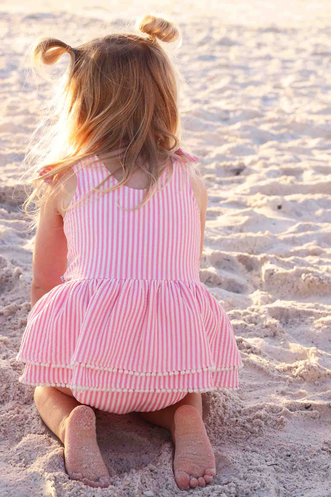 back view of pink seersucker tiered skirt one piece swimsuit 