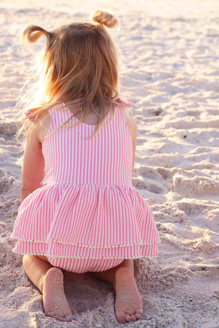 back view of pink seersucker tiered skirt one piece swimsuit 