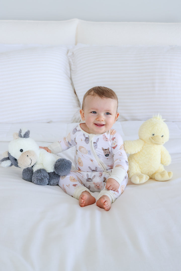 baby boy playing with cow and duck stuffed animal 