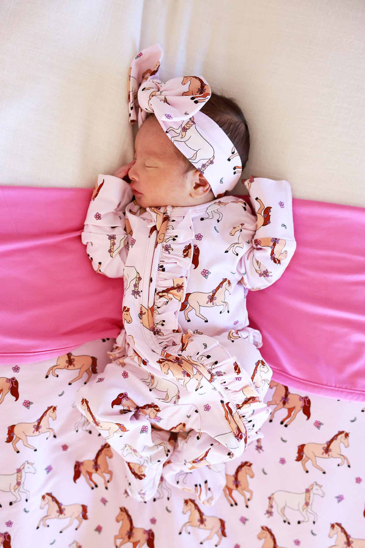 newborn girl in pink pony and flower ruffle zipper footie