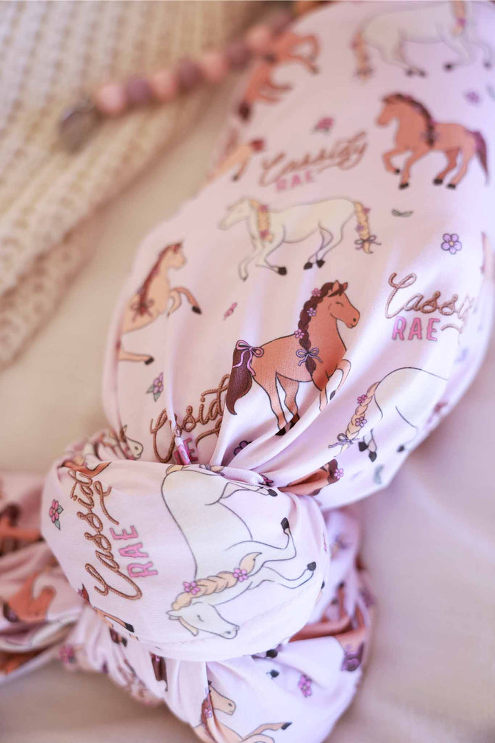 closeup of girly pony and flower personalized swaddle blanket 