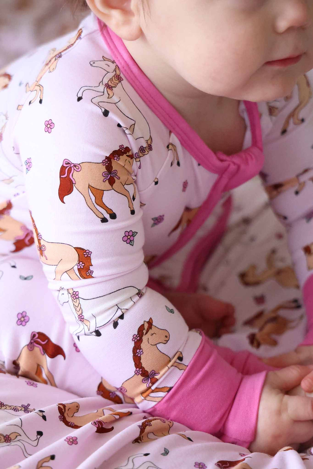 closeup of arm of pony club pink convertible zip romper pajama 