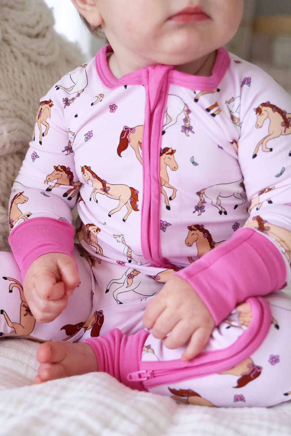 closeup of pony club pink bamboo zip romper pajama with hot pink trim 