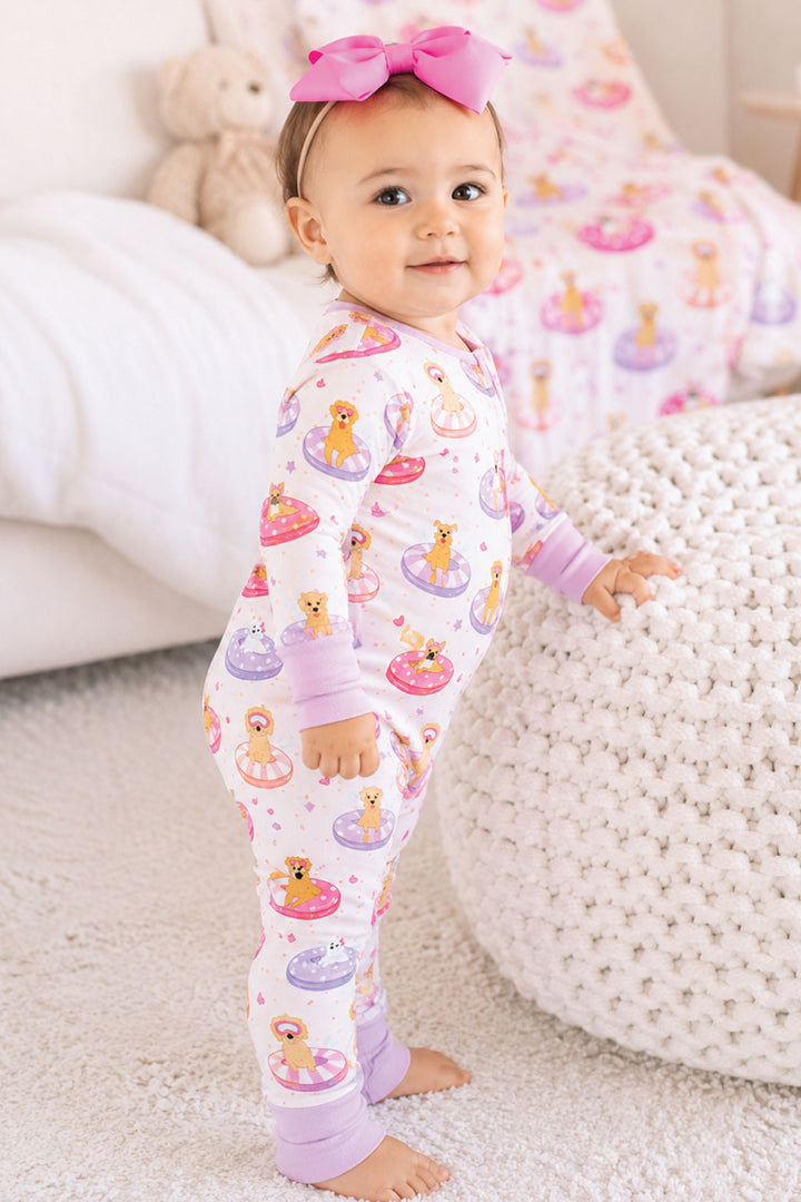 standing girl leaning against ottoman in poolside pups pink convertible zip romper pajama 