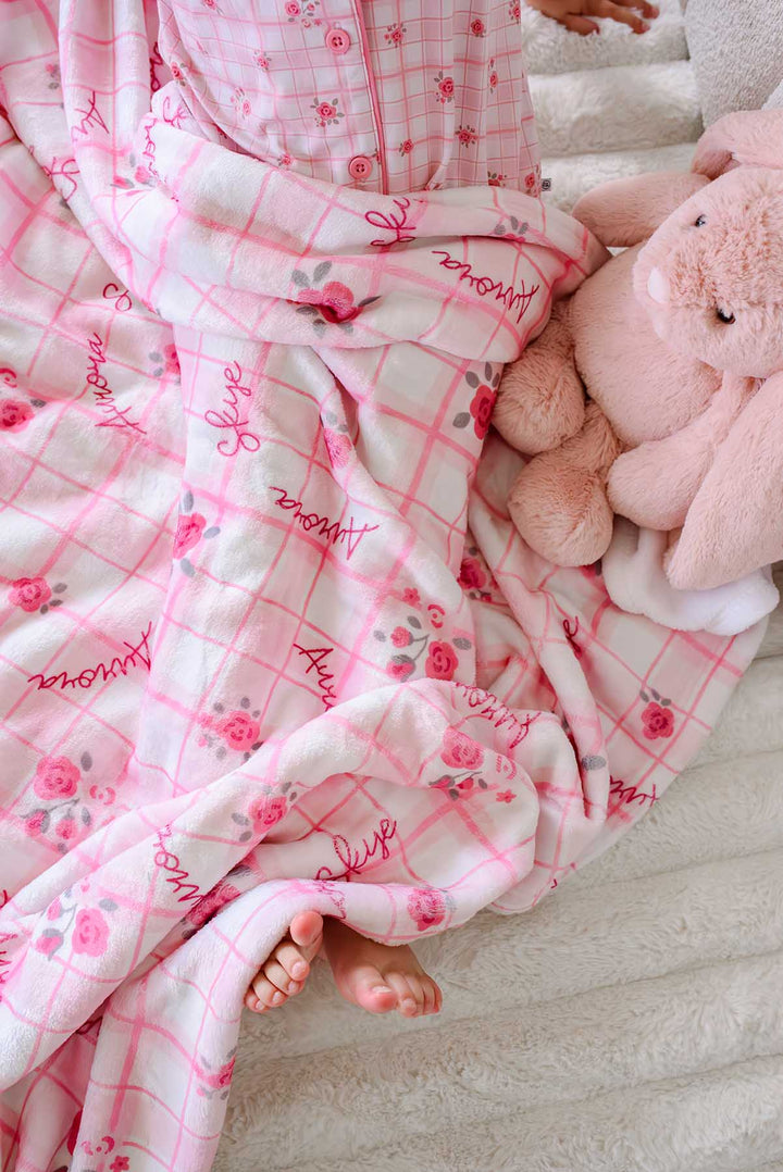 Feet peeking out from personalized Primrose Plaid blanket near bunny
