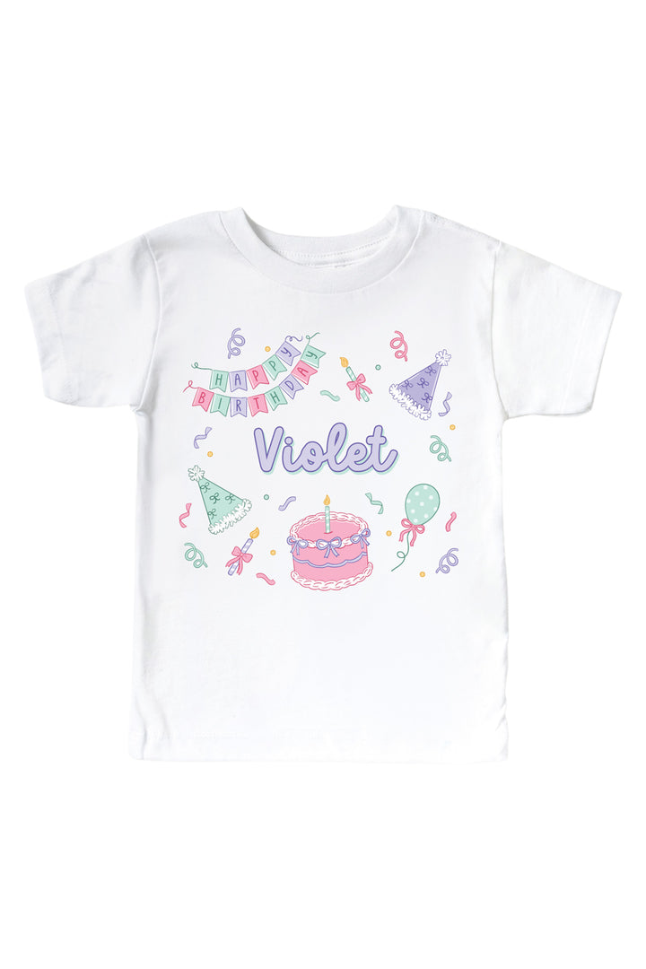 Caden Lane personalized Birthday Bash white kids' t-shirt with a pink "Happy Birthday" banner, party hats, cake, and the name "Violet" in purple.