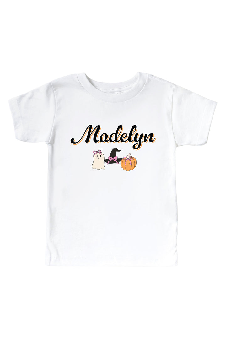 Caden Lane personalized Halloween shirts featuring a custom name in script with a ghost, witch hat, and pumpkin design — shown as a kids' t-shirt, personalized here with the name 'Madelyn'