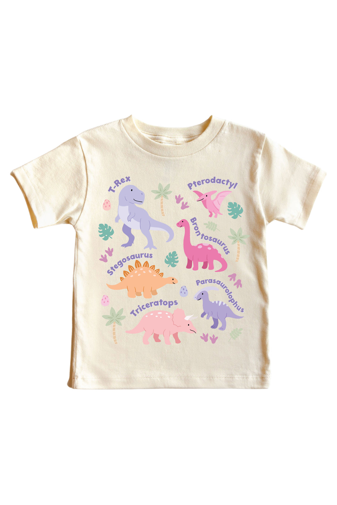 Natural cream kids tee with multiple named pastel dinosaurs including T-Rex, Pterodactyl, Brontosaurus, Stegosaurus, Triceratops, and Parasaurolophus in pink and purple with leaf accents