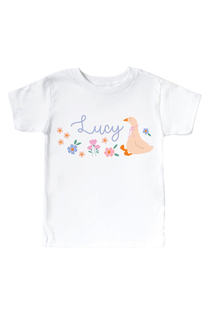 White kids graphic tee mockup with personalized name Lucy and Lucy Goosy goose and floral graphic design on a white background