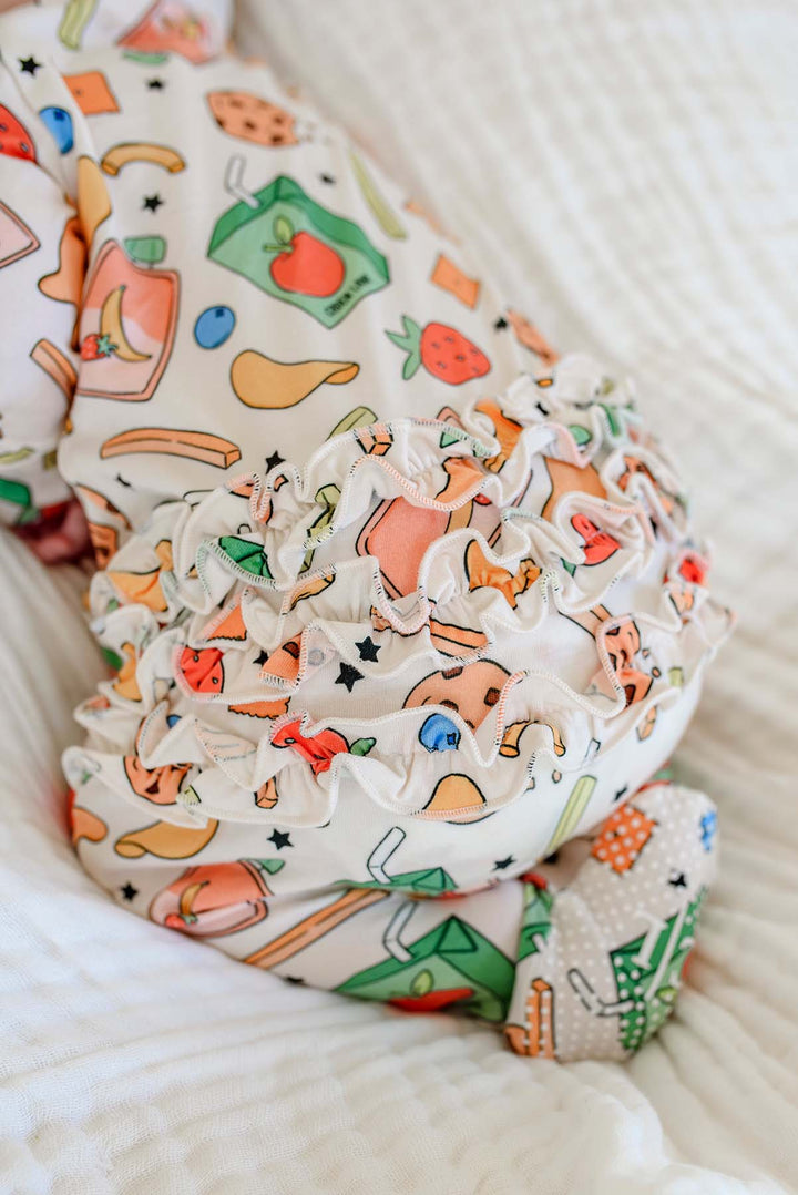 Close-up detail of the signature ruffle bum on a newborn wearing the Snack Attack Ruffle Bamboo Zipper Footie, showcasing the abundant ruffle trim in the Snack Attack bamboo print