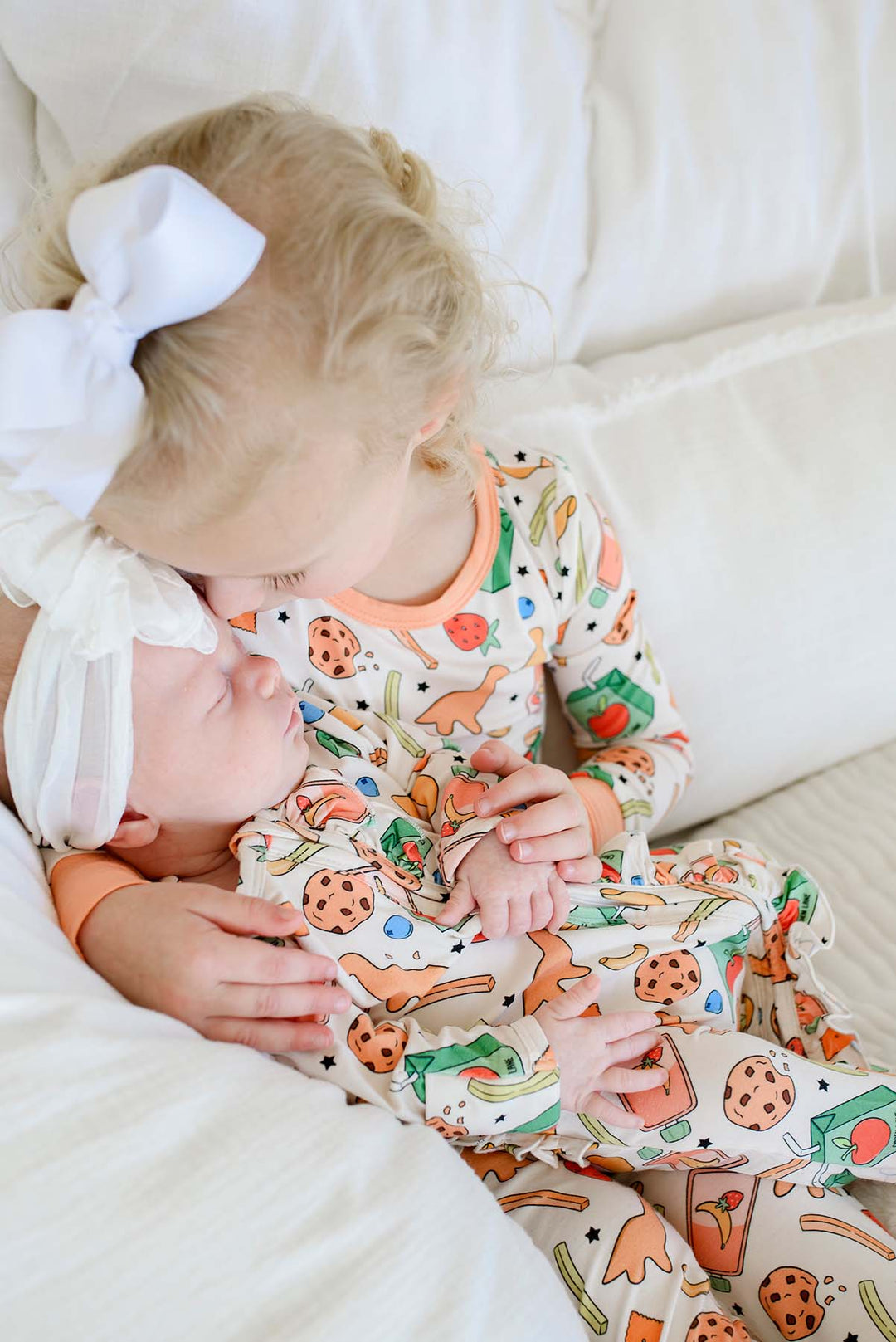 Close-up of a newborn's feet and legs from the Snack Attack sibling photo session, wearing the Snack Attack Ruffle Bamboo Zipper Footie with the ruffle bum detail visible
