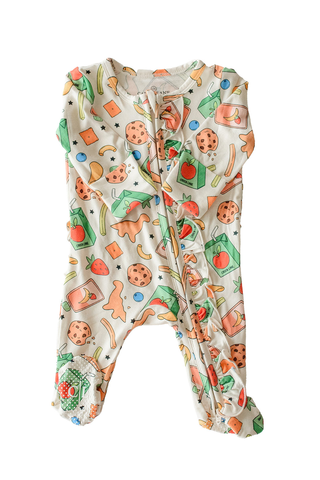 Flat lay of the Snack Attack Ruffle Bamboo Zipper Footie on a white background, showing the full one-piece footie with ruffle details, the colorful snack print featuring cookies, juice cartons, dinosaur crackers, and strawberries, with a front zipper closure
