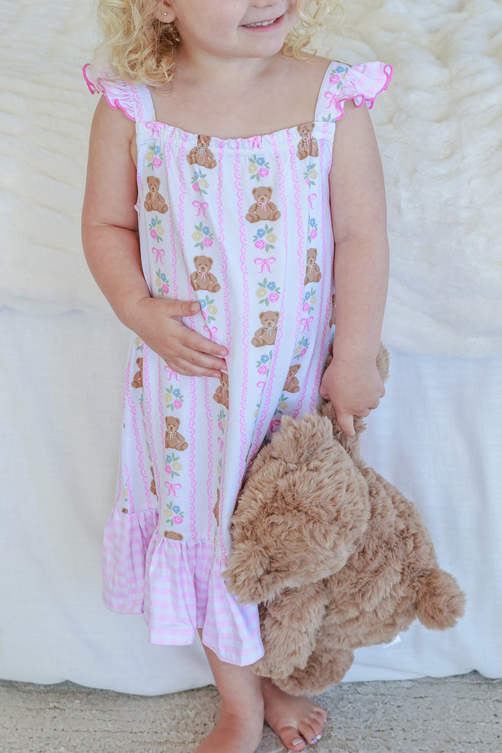 Young girl carrying teddy bear wearing Full Length Ruffle Nightgown in Beary Lovely print, front view showing full dress length and pink ruffle hem