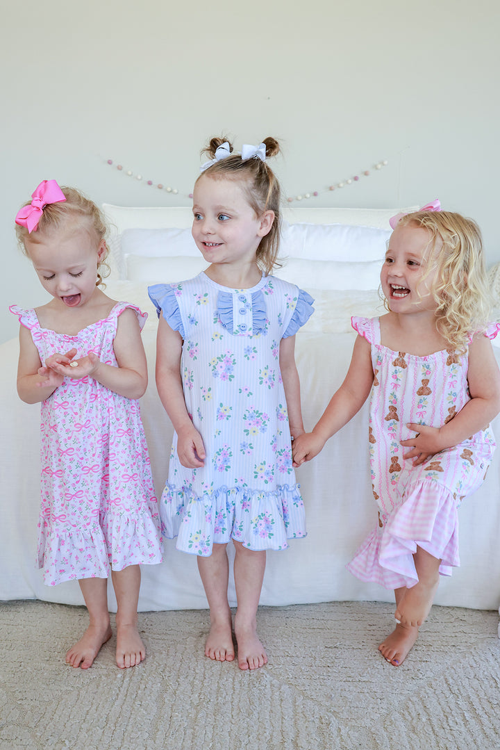 Three young girls wearing ruffle nightgowns including Full Length Ruffle Nightgown in Dreamy Bows pink print on left, lifestyle group shot