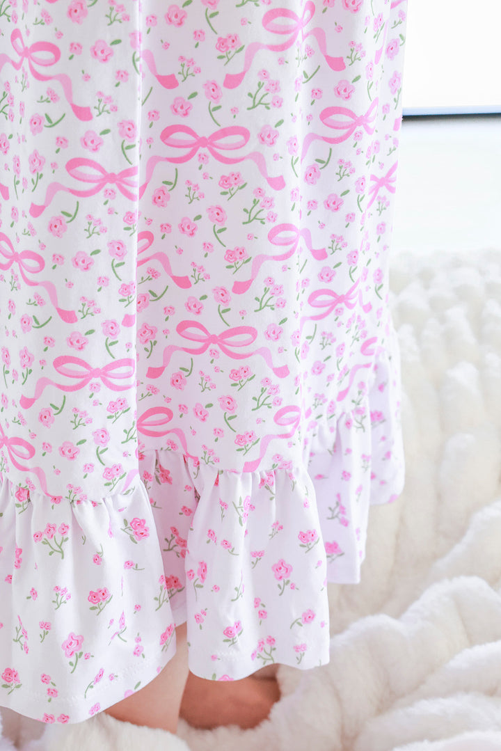 Young girl wearing Full Length Ruffle Nightgown in Dreamy Bows pink bow print, full front view with ruffle hem detail