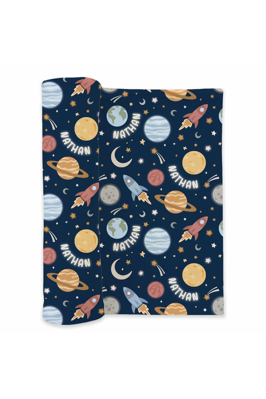 Flat lay of a partially unrolled Caden Lane navy knit swaddle in a Stellar Snuggles print featuring planets, rockets, and moons, reading “Nathan.”