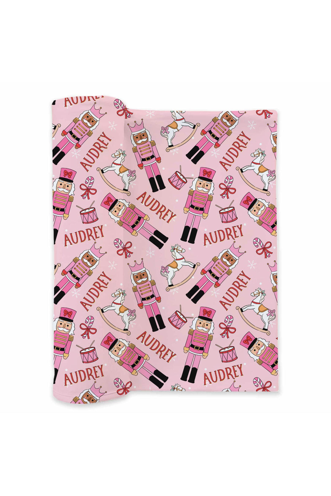 Personalized Caden Lane Christmas blanket featuring pink nutcrackers, rocking horses, drums, bows, snowflakes, and a custom child’s name.