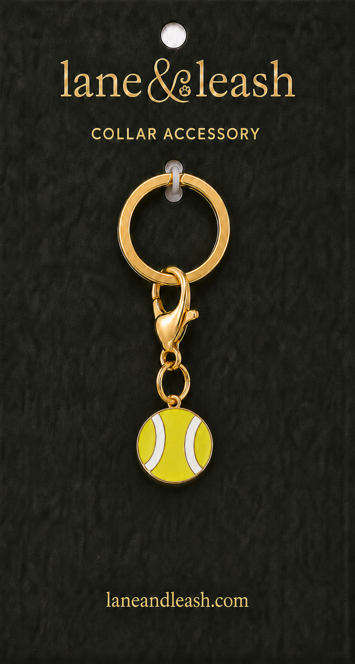 Yellow tennis ball Lane & Leash collar accessory charm displayed on dark green packaging card with lobster claw clasp and jump ring
