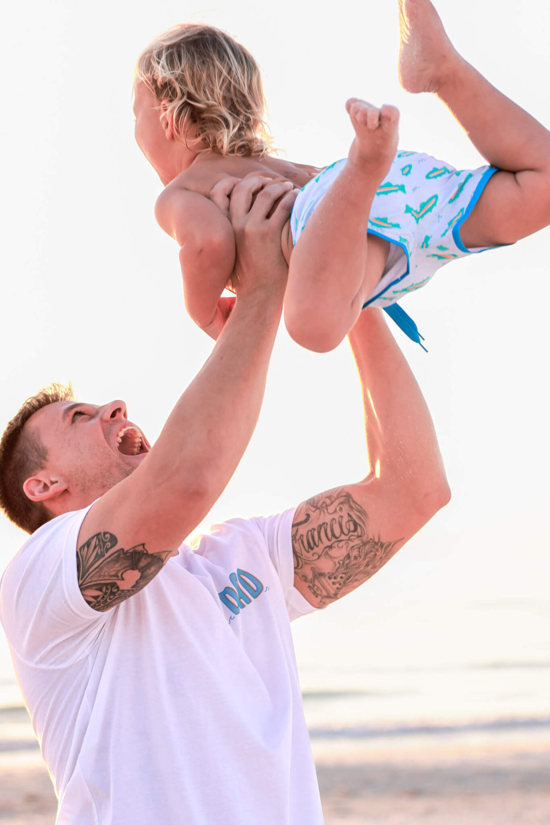 dad playing with son wearing white cotton dad tee