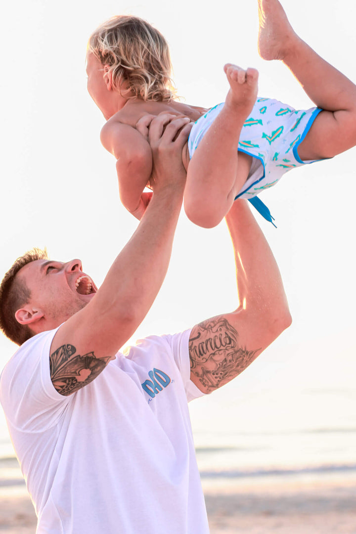 dad playing with son wearing white cotton dad tee